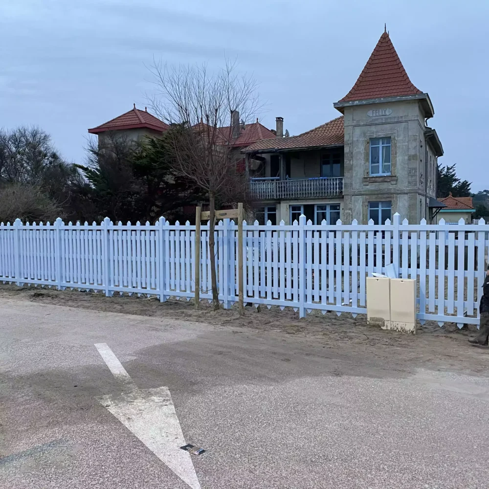 Pose d'une grande clôture bois persiennée bleu clair assortie aux menuiseries Jagaud Petit.