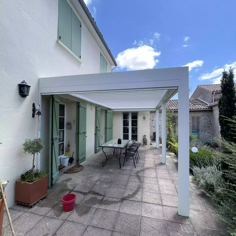 Pergola bioclimatique intégrée à une maison en pierre, Jagaud Petit.
